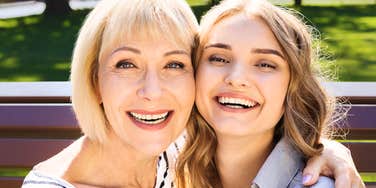 Mother and adult daughter sharing a joyful moment outdoors, highlighting the daily habits and psychological patterns that sustain close parent-child relationships.