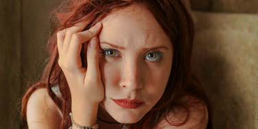 Woman with her hand on her face, appearing low and withdrawn, illustrating quiet slumps and strategies to climb back out