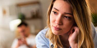 woman experiencing intellectual loneliness while husband scrolls his phone blindly