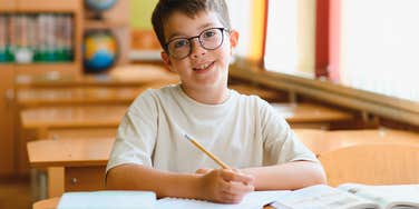 young student working on his handwriting at school