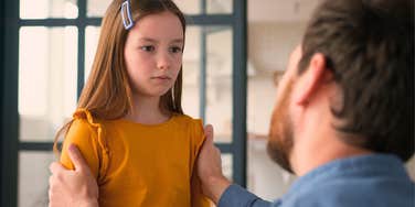 dad talking sternly to daughter 