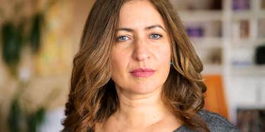 A woman with an intense, reflective expression, capturing the mindset of a self-assured individual who understands the value of setting boundaries and acting on her own behalf.