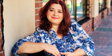 A confident, smiling woman in her fifties enjoying a sunny day in the city, embodying the 'faith in herself' and modern vitality described in her story of mid-life romance