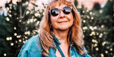 A portrait of a vibrant woman in her fifties, representing the 'two-minute' lifestyle shifts and neuroprotective strategies that support long-term brain health.