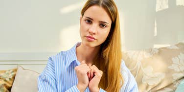 introverted woman sitting at home on her couch