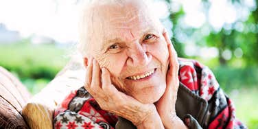 A vibrant, happy 90-year-old woman smiling outdoors, illustrating the physical and emotional vitality that comes from maintaining consistent, science-backed lifestyle habits.