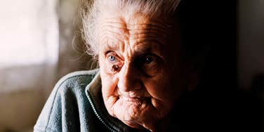 A centenarian woman with a reflective and peaceful expression, representing the wisdom and simple daily habits that contribute to extreme longevity.