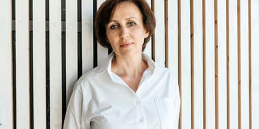 A mature woman in her 50s staring blankly ahead with a resolute expression, illustrating the moment of emotional clarity when you stop tolerating life's unnecessary stressors.