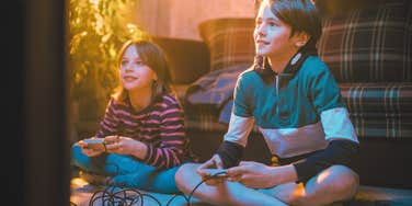 siblings playing super mario bros video games at home in the 1990s