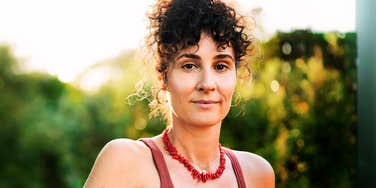 A confident, smiling woman on a patio, representing the demographic that many now surprisingly categorize as 'old' according to new age-perception data.