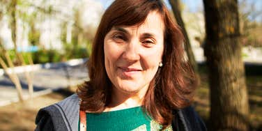 A portrait of a beautiful smiling senior woman with brown hair, illustrating 'positive affect' and the emotional maturity of the fifties and sixties.