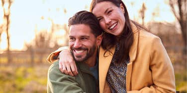 A couple with a high relationship IQ showing love outdoors in the fall