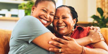 smiling woman hugging her hard-working mom laughing together