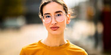 fake cold-hearted woman looking serious standing outside
