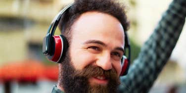 A portrait of a man enjoying music through headphones, representing 'sensory enrichment' and its 39% impact on lowering cognitive decline risk.