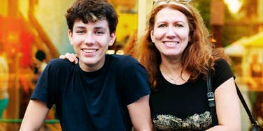 A mother and her adolescent son laughing together at sunset, illustrating the 'secure attachment' and emotional proximity that are often overlooked upsides of high-engagement parenting.