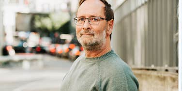 A portrait of a mature man walking with a focused expression, representing 'proprioceptive input' and the one habit that regulates the nervous system in mid-life.
