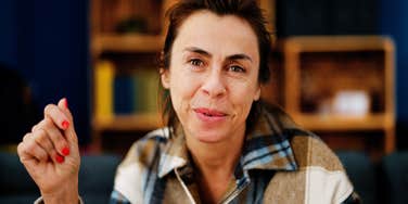 Middle age hispanic woman smiling confident sitting on sofa at home