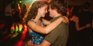 A nostalgic AI image of a high school girl slow-dancing with an ecstatic smile; illustrating the romantic energy of the era's classic love songs.