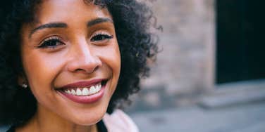 truly special and happy woman smiling standing outside
