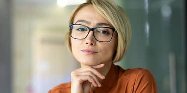 type a woman with glasses resting head on hand