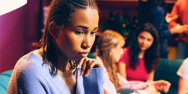 young woman feeling like she doesn't belong in group of friends