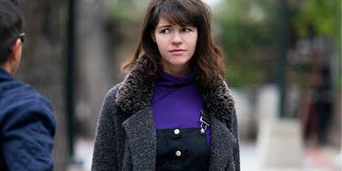 Young woman secretly judging a man on a city street