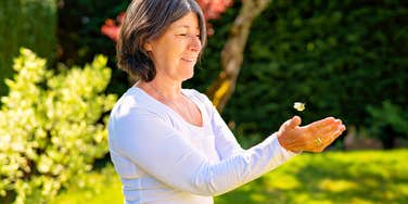 woman with rare emotional gifts releasing a bug outside after saving it
