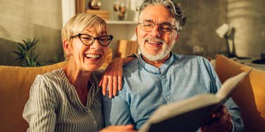 older couple looking at photo album reminiscing with nostalgia