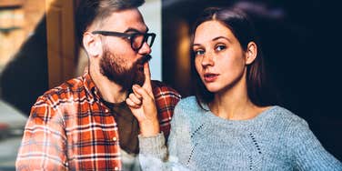 woman shushing man while she attempts to rage bait him