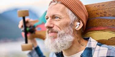 Boomer man who learned a lot form Gen Z holding skateboard