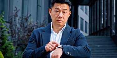 Narcissistic employer looks expectantly at his watch