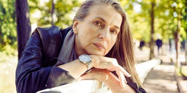 A portrait of a mature woman in a moment of physical reflection, representing the 'silent symptoms' of gut dysbiosis and metabolic shifts in later life.