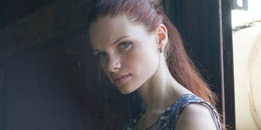 Woman who feels like a hermit and keeps herself at home in a room by a window