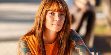 Redheaded woman who finally found peace in her own mind smiling in the sun