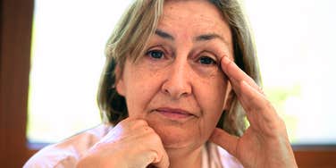 A close-up portrait of a senior woman with a natural, thoughtful expression, representing the quiet strength and resilience of those navigating loneliness in their fifties and sixties.