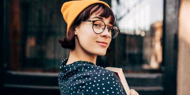 woman with glasses holding book