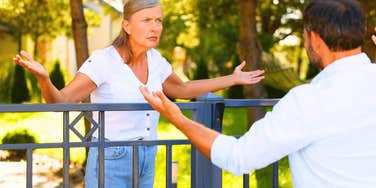 neighbors who can't stand each other arguing across their shared fence