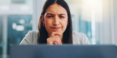 pensive woman looking at computer not using ai or chatgpt for help
