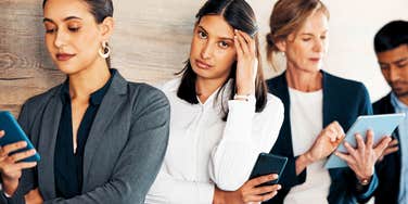 frustrated young businesswoman refusing to wait in line with colleagues