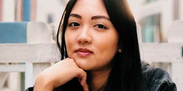 A cool and collected woman looking relaxed outdoors; a visual of the mental equanimity and stress management habits used to navigate unpredictable situations.