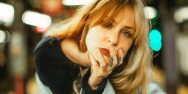 Close-up portrait of a woman leaning forward with her hand on her face; a visual representation of the hyper-focused intensity often found in people with high-conflict personalities.