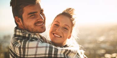 Couple who are happily married to the right person smile together in the sun