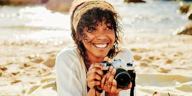 A young woman capturing a joyful moment on her camera; a visual of the rare daily rituals happy people use to maintain a positive mindset regardless of their mood.