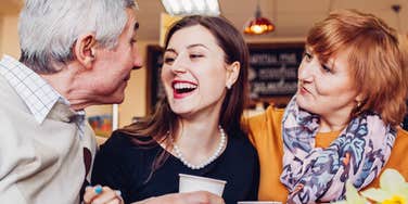 Parents who respect their grown daughter laugh together at a restaurant