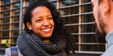 woman in a conversation smiling but ruining a good first impression