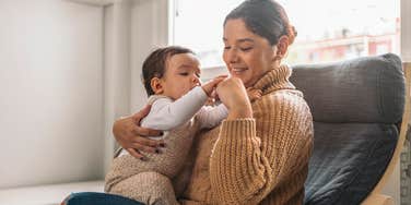 mom sitting in chair and holding baby
