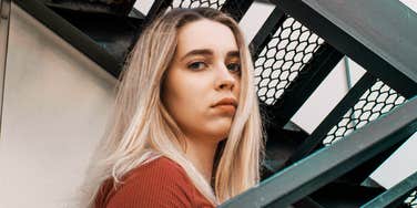 A pensive portrait of a woman staring directly into the camera; illustrating the quiet intensity and analytical mind often associated with the world's most talented and intelligent individuals.