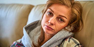 emotionally exhausted woman sitting on couch feeling done