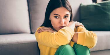 sad woman dissociating sitting on the floor